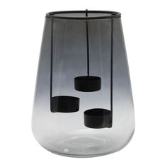 a black and white vase with three candles in it