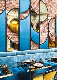 a restaurant with blue booths and round mirrors on the wall