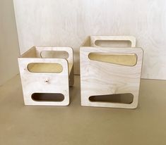 two wooden boxes sitting on top of a table next to each other with holes in them