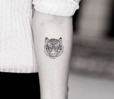 a black and white photo of a tiger tattoo on the arm