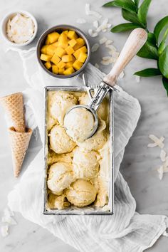 an ice cream sundae with mango chunks and two scoops of vanilla ice cream