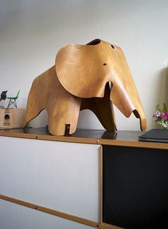 an elephant statue sitting on top of a wooden shelf