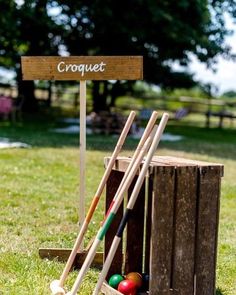 a croquet set up in the grass next to a wooden box with balls