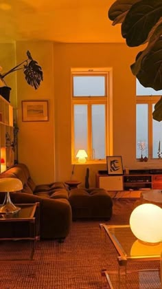 a living room filled with lots of furniture next to a tall plant in front of a window