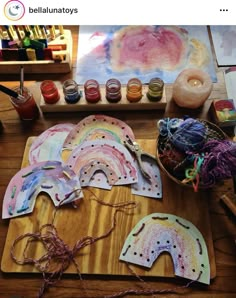 some art supplies are sitting on a table with yarn and watercolors in the background