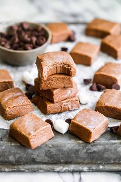 several pieces of chocolate fudge with marshmallows on a baking sheet next to it