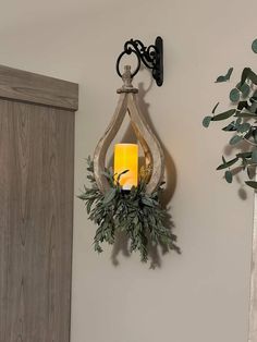 a candle is lit on the wall next to a potted plant and door handle