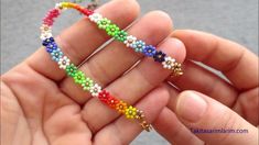 a person holding a colorful beaded bracelet in their hand