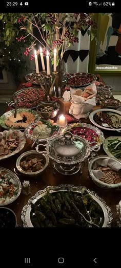 a table filled with lots of food and candles on top of it's sides