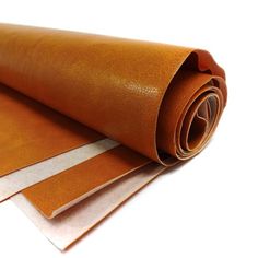 two rolls of brown leather sitting on top of each other, one rolled up and the other rolled down