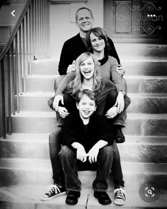 a black and white photo of a family sitting on the stairs