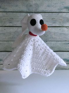 a white crocheted snowman ornament hanging from a string