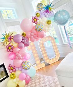 the balloon arch is decorated with balloons and emoticting smiley faces for an 80th birthday celebration