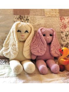 three knitted stuffed animals sitting next to each other on a quilted bed spread