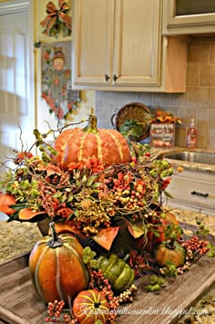 pumpkins and gourds are arranged on a cutting board in the kitchen counter