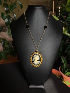 Handmade replica of Shilo Wallace's necklace from 'Repo The Genetic Opera.' Materials: - Gold colored chain.  - Black beads. - Gold colored cabochon setting.  - Lady with ponytail cameo cabochon.  - Gold colored lobster claw clasp. - Gold colored jump rings.  - Epoxy glue.  Measurements: - Necklace length: 18 inches.  - Pendant width: 2 inches.  - Pendant height: 2.5 inches.  Shipping information:  Shipping to Canada Standard shipping:  - No tracking number. -  approximately 2-3 weeks. Xpresspos Vintage Beaded Necklace With Adjustable Chain For Gift, Antique Cabochon Necklace With Round Pendant, Antique Cabochon Round Pendant Necklace, Gold Necklaces With Cabochon For Collectors, Handmade Antique Black Necklace, Vintage Black Beaded Necklace For Gift, Black Round Pendant Necklace Collectible, Vintage Black Chain Jewelry, Antique Handmade Black Necklace