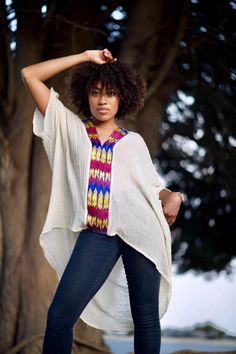 Boldly Cozy With A Boho Twist. Simply-Chic Layering piece, that dresses up or down for any occasion.• V-Neck and flattering drape• 100% Cotton • V-neck • Embroidery By Hand In Ethiopia. • Made in California.• size one size fits most { the size is loose fit it well fit from size 2 to size 12 } • front length 23” from the shoulder. • Machine wash In Delicate cycle or hand was in cold water. Tumble dry low heat for crinkle look. • Color off white / beige/ the embroidery is multi color. Oversized Bohemian Short Sleeve Blouse, Free Size Short Sleeve Blouse, Casual Free Size Tunic With Batwing Sleeves, Bohemian Oversized Tunic Tops, Oversized Bohemian Tunic Tops, Free Size Casual V-neck Tunic, Oversized Tunic Top For Vacation, Oversized Short Sleeve Poncho, Free Size Tunic Top For Vacation