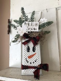 a snowman made out of perforated white bricks with red and black bows