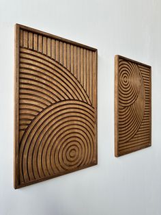 two wooden art pieces hanging on the wall