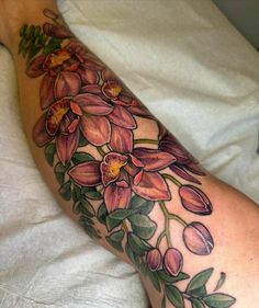 a woman's leg with flowers and leaves on it