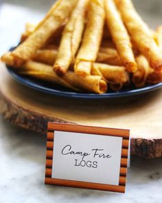 french fries on a plate with a sign that says camp fire logs next to it