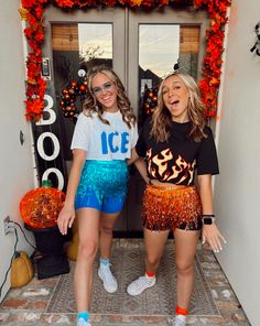 two young women standing next to each other in front of a door decorated for halloween