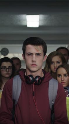 a young man with headphones standing in front of a group of people wearing headphones