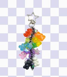 a bunch of gummy bears hanging from a star shaped keychain on a checkered background