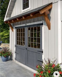 a gray garage with two doors and windows