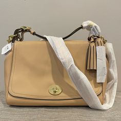 Coach Legacy Top Handle Handbag In Sand With Tassels And Removal Adjustable Shoulder Strap Original Packaging Duster Included Beige Coach Bag With Detachable Strap, Coach Flap Bag With Detachable Strap, Coach Satchel Flap Bag With Removable Pouch, Coach Flap Shoulder Bag With Removable Pouch, Coach Satchel With Flap, Coach Shoulder Bag With Removable Pouch And Flap, Coach Beige Satchel Bag, Coach Flap Shoulder Bag With Detachable Handle, Coach Flap Bag For Everyday Use