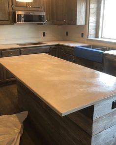 an empty kitchen with wooden cabinets and white counter tops in the process of remodeling