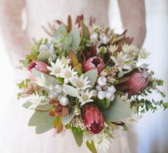 a bridal holding a bouquet of flowers and greenery