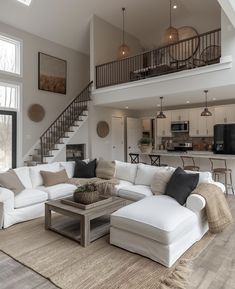 a living room filled with lots of furniture and a staircase leading up to the second floor