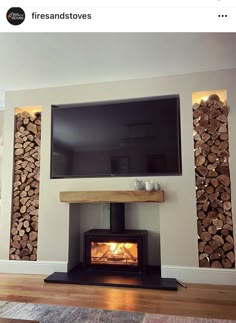 a television mounted on the wall above a fire place in a living room with wood stacked around it