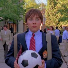 a man in a suit holding a soccer ball