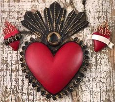 a red heart with two small hearts on it and some other decorations around the perimeter