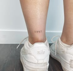 a woman's legs with a small tattoo on her left leg and the number 1971