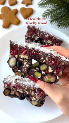 two pieces of food on a white plate with cookies and christmas decorations in the background