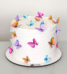 there is a white cake with butterflies on it