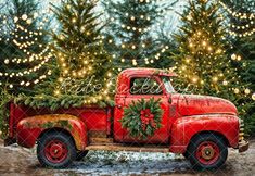 an old red truck with christmas trees in the back