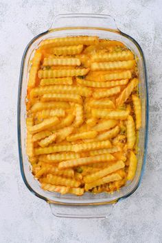 a casserole dish filled with cheesy pasta and sauce on a table