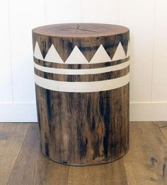 a wooden stool sitting on top of a hard wood floor next to a white wall