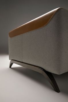 an upholstered couch with a brown leather seat and back rest, on a gray background