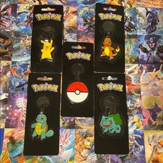 four different pokemon keychains are on display in front of a mosaic pattern background