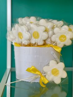 a bucket filled with marshmallows on top of a glass table next to a green wall