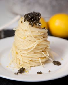 a white plate topped with pasta covered in sauce and garnished with black pepper