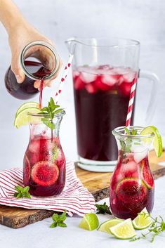 two pitchers filled with liquid and garnished with limes