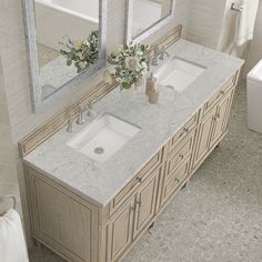 two sinks and mirrors in a bathroom with marble counter tops, white walls and beige flooring