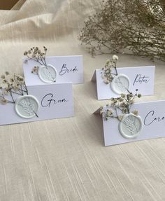 four place cards with dried flowers on them