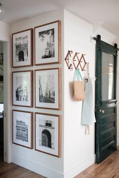 a wall with pictures hanging on it and a coat rack in front of the door